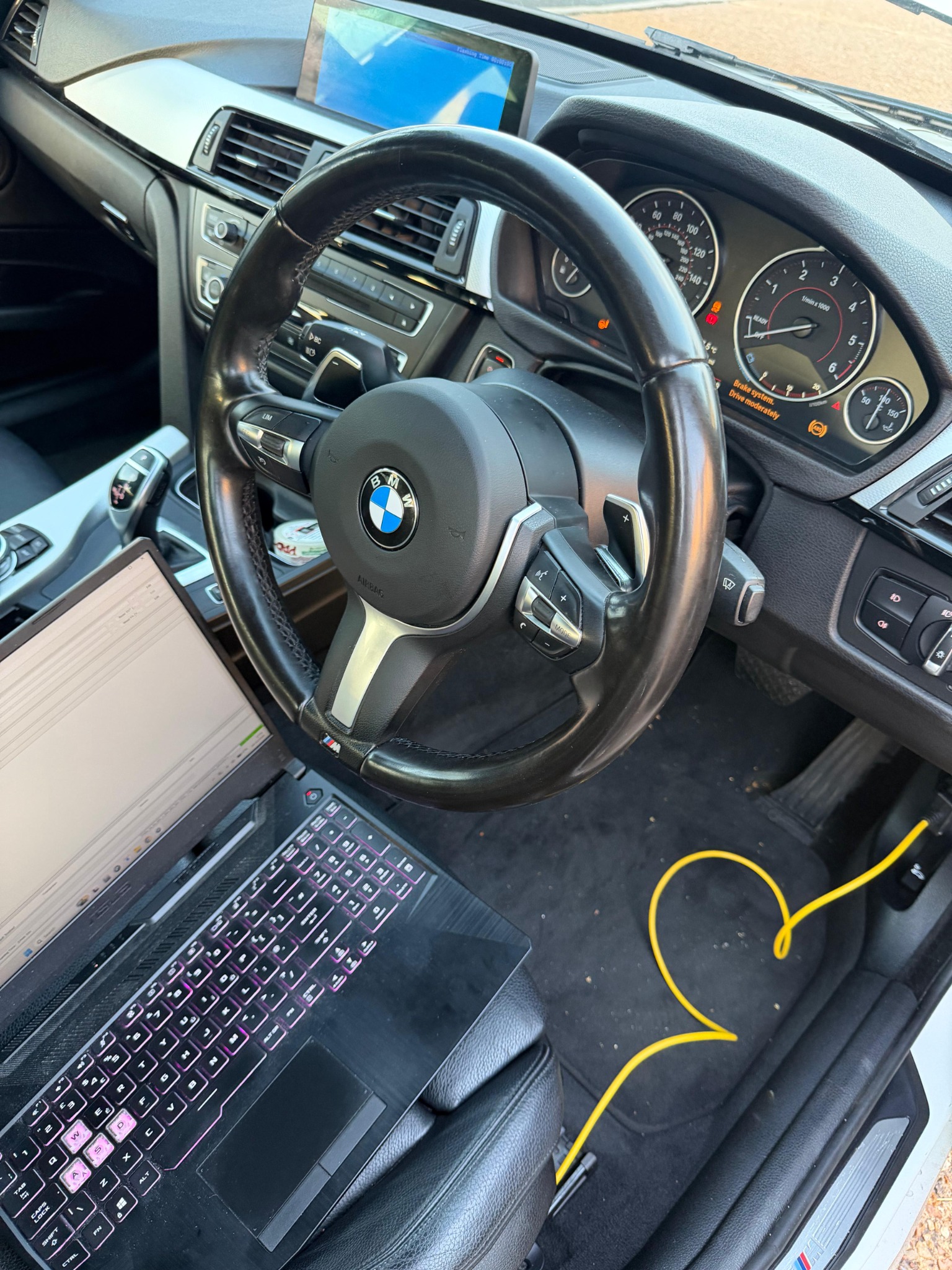 BMW connected to a laptop for coding